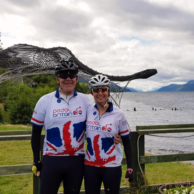 Two people stood in cycling gear having picture taken.