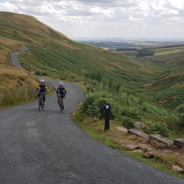 Cyclists riding up hill in Forest of Bowland