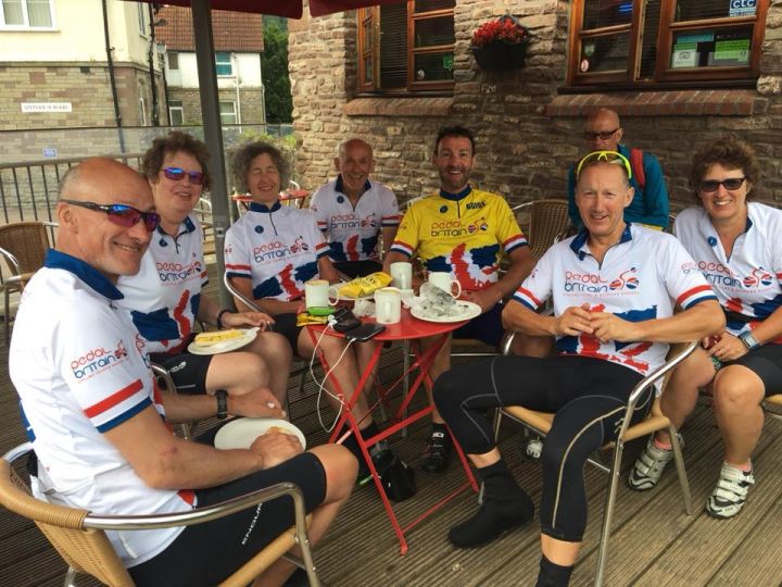 group of lejog cyclists sat at table and chairs eating lunch